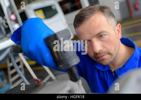 Mechanic using tool Stock Photo