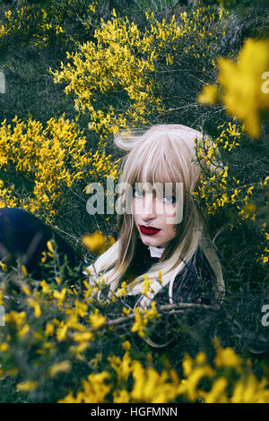 Portrait of a young woman between a lot of yellow flowers