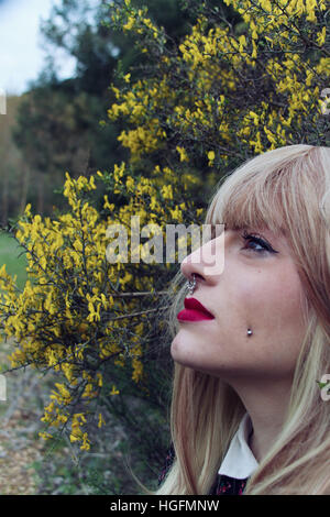 Young woman look into space with a lot of yellow flowers as background