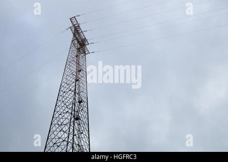 Silhouette of electricity post on blue sky background,low angle shot,high voltage electric pole,  power supply  cloudy day. Stock Photo