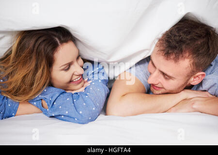 Shot of loving young couple under their duvet Stock Photo