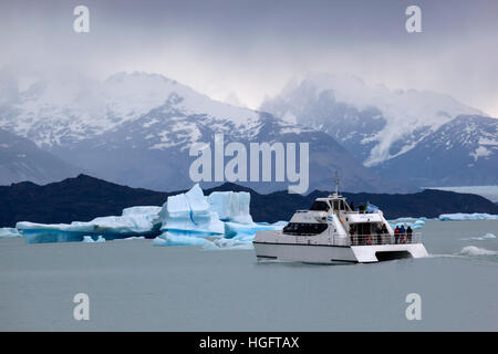 Boat below iceberg near Upsala Glacier on Lago Argentino, El Calafate, Parque Nacional Los Glaciares, Patagonia, Argentina Stock Photo