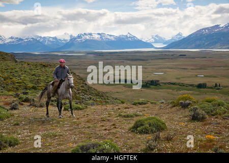 Gaucho on horseback at Estancia Alta Vista with the Andes and Perito Moreno Glacier, El Calafate, Patagonia, Argentina Stock Photo