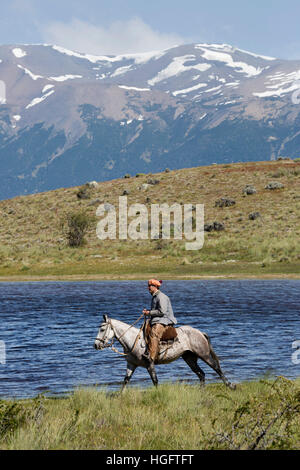 Gaucho on horse by lake at Estancia Alta Vista, El Calafate, Parque Nacional Los Glaciares, Patagonia, Argentina, South America Stock Photo