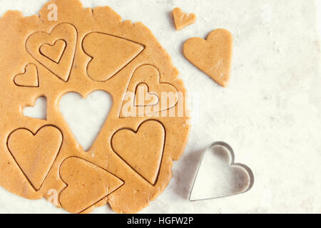 Making homemade heart shaped cookies from ginger raw dough - festive homemade cookies pastry for Valentine day Stock Photo