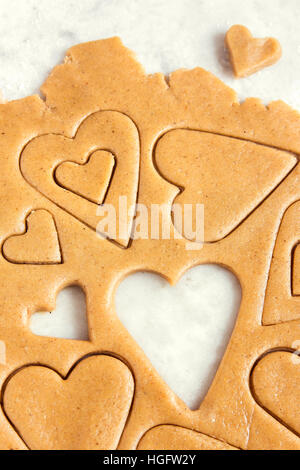 Making homemade heart shaped cookies from ginger raw dough - festive homemade cookies pastry for Valentine day Stock Photo