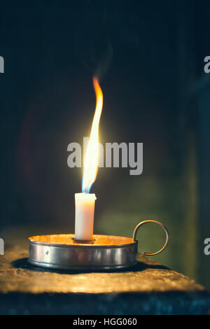 Victorian old wax candle with flickering flame Stock Photo
