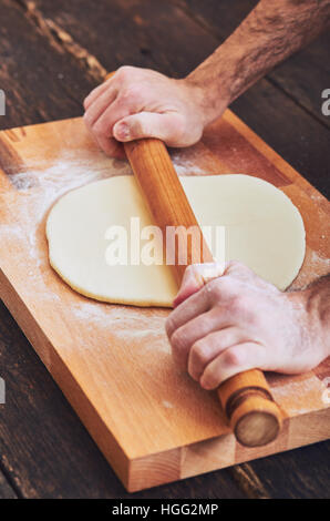 Making handmade pasta with wooden rolling pin Stock Photo