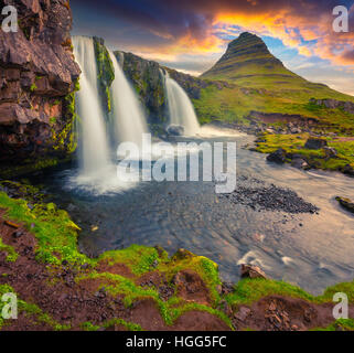 Summer sunset on famous Kirkjufellsfoss Waterfall and Kirkjufell mountain. Dramatic evening scene on Snaefellsnes peninsula. Stock Photo