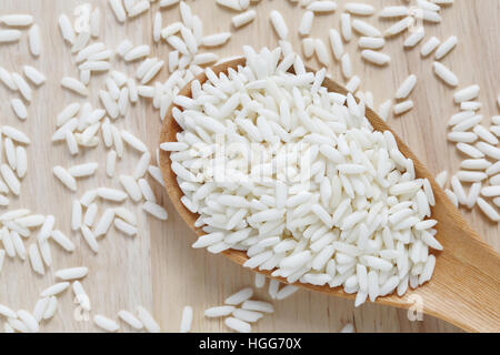 Organic white rice in wooden spoon, glutinous rice or sticky rice for design nature foods Concept. Stock Photo