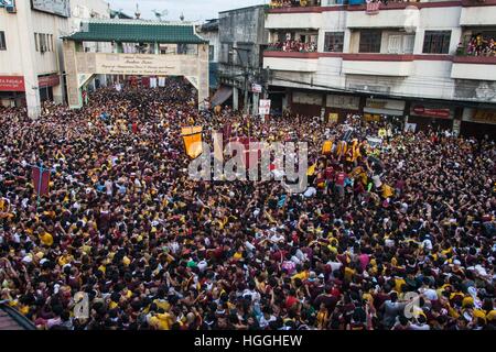 The carriage of the Black Nazarene as it makes its way through the welcome arch of the Muslim Town in Quiapo, Manila. Millions of barefoot Catholic devotees participate on the annual Black Nazarene Traslacion in Manila. Many Black Nazarene devotees believe that by pulling the carriage rope of the statue willl help in the antonement of their sins. 9th Jan, 2017. © J Gerard Seguia/ZUMA Wire/Alamy Live News Stock Photo