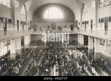 Immigrants seated on long benches, Main Hall, U.S. Immigration Station.  - Ellis Island Immigration Station 1902-1913 Stock Photo