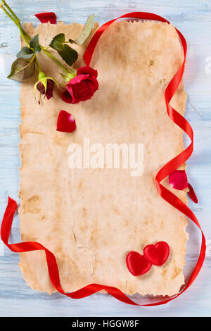Ancient paper, roses ribbon and hearts. Stock Photo