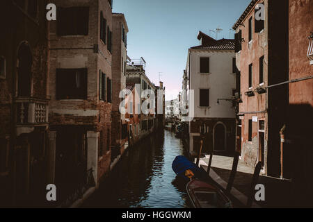 A narrow canal with a few boats in Venice, Italy. Stock Photo