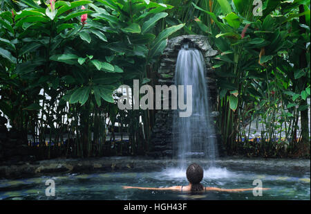 A woman is relaxing in a Thermal bath close to the volcano Arenal, La Fortuna, Costa Rica, Central America