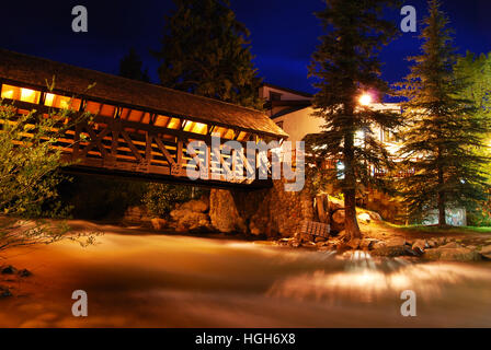 This covered bridge is lit up at night in Vail, Colorado, a popular summer and winter vacation destination for mountain bikers, skiers, and snowboarde Stock Photo