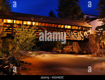 Nighttime photograph of a covered bridge and stream in Vail, CO. Stock Photo