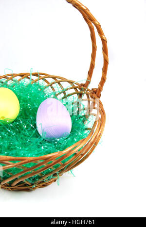 Easter Basket with pastel eggs and fake green grass. Stock Photo