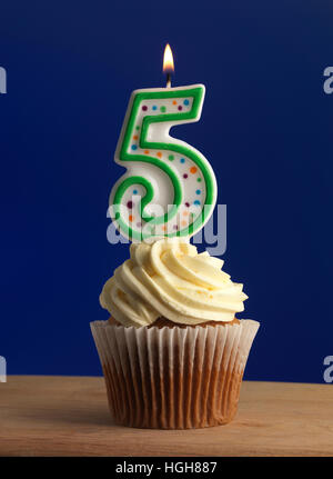 Cupcake with a number five candle with a Blue Background Stock Photo