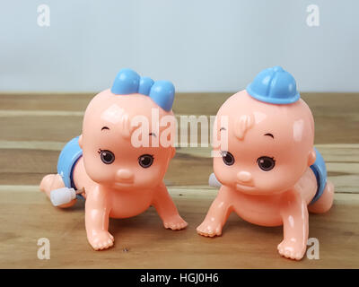 Mechanical wind up crawling baby toy on wood background Stock Photo