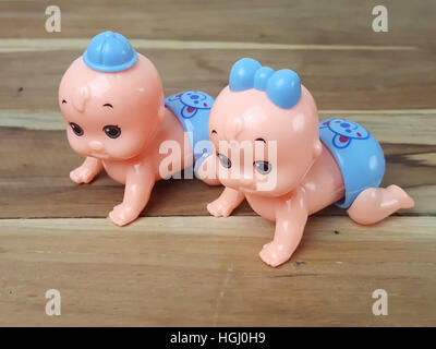 Mechanical wind up crawling baby toy on wood background Stock Photo