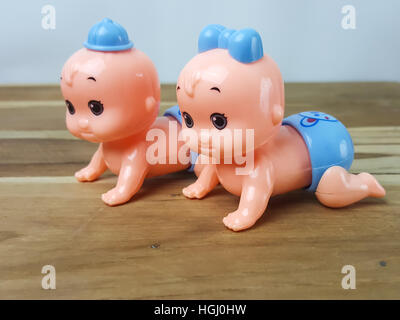 Mechanical wind up crawling baby toy on wood background Stock Photo