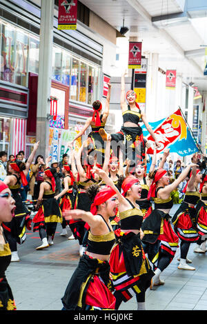 Japan, Kumamoto. Hinokuni Yosakoi Dance Festival. Female team performing historical dance in shopping arcade. Line of women, arms outstretched.