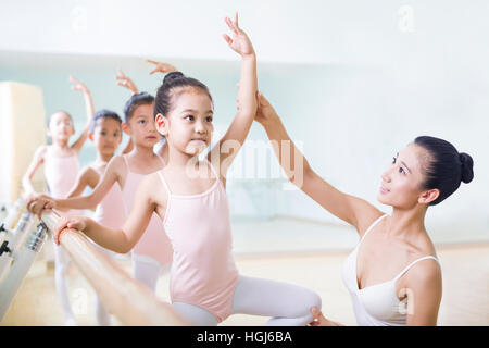 Young ballet instructor teaching girls in ballet studio Stock Photo