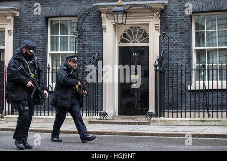 Armed police patrol outside No 10 Downing Street in London. Stock Photo