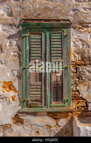 Old window shutter with peeling paint on Symi Greece Stock Photo