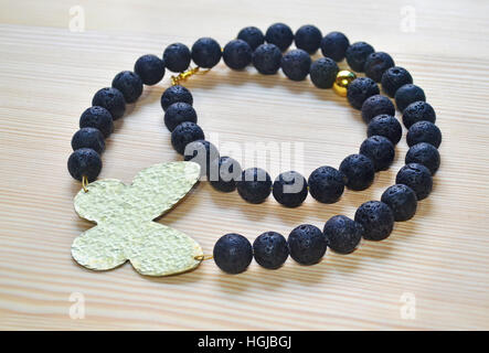 gemstone black lava necklace with gold butterfly Stock Photo