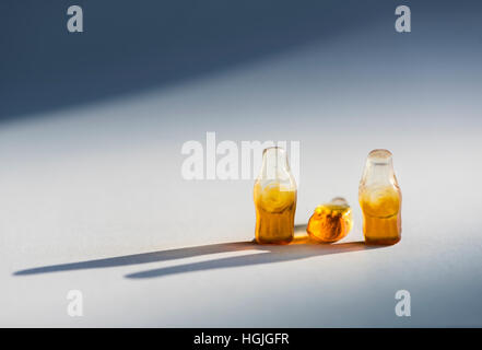 Group of three soft candy / jelly beans in the shape of bottles. Looks like group of three people. Middle bottle is toppled over Stock Photo