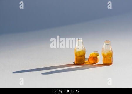 Group of three soft candy / jelly beans in the shape of bottles. Looks like group of three people. Middle bottle is toppled over Stock Photo