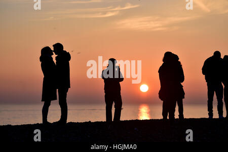 Brighton Sussex, UK. 22nd Jan, 2017. A couple enjoy a romantic moment on Brighton beach as the sun sets behind them at dusk after a cold but beautiful day on the south coast Credit: Simon Dack/Ģ����ý Live News Stock Photo