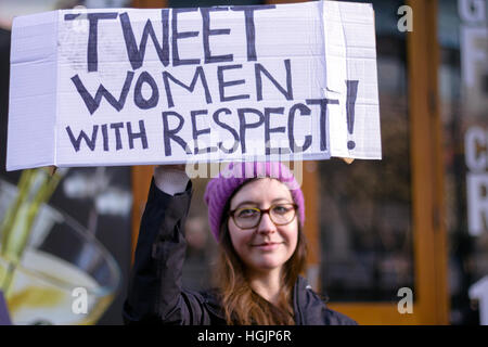 A woman holds her handmade anti- Trump sign high in support of Women's March, Seattle, USA. Stock Photo