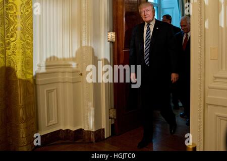 Washington, USA. 22nd Jan, 2017. United States President Donald Trump arrives to a swearing in of White House senior staff in the East Room of the White House. Trump earlier today mocked protesters who gathered for large demonstrations across the U.S. and the world on Saturday to signal discontent with his leadership. Credit: Andrew Harrer/Pool via CNP/MediaPunch/Alamy Live News Stock Photo