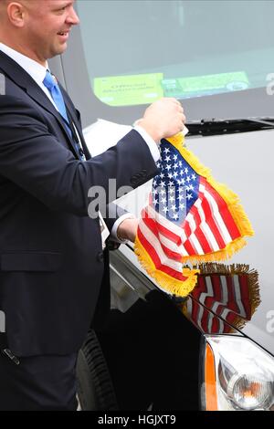 Washington, Us. 20th Jan, 2017. Secret Service agents attach U.S. flags to a motorcade vehicle during the 2017 Presidential Inauguration at the U.S. Capitol. Credit: Jack Gruber/Pool via CNP - NO WIRE SERVICE - Photo: Jack Gruber/Consolidated/dpa/Alamy Live News Stock Photo