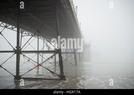 Under Worthing Pier on a foggy day at low tide in Worthing, West Sussex, England. Stock Photo