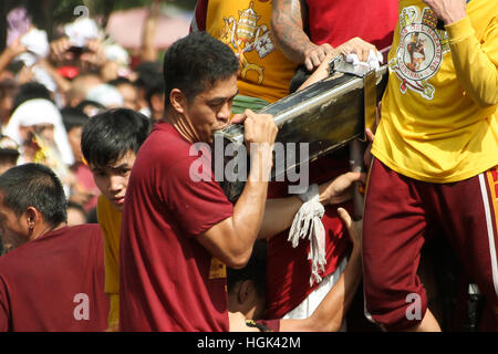 Manila, Philippines. 09th Jan, 2017. A devotee reverently kisses the cross of the miraculous Icon of the Black Nazarene. Devotees observe this tradition of touching the Icon of the Black Nazarene, hoping that through this act, their sins may be forgiven and that they may obtain graces and answered prayers from Jesus Christ. © Dennis Jerome Acosta/Pacific Press/Alamy Live News Stock Photo