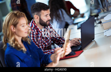 Programmers cooperating at  IT company developing apps Stock Photo