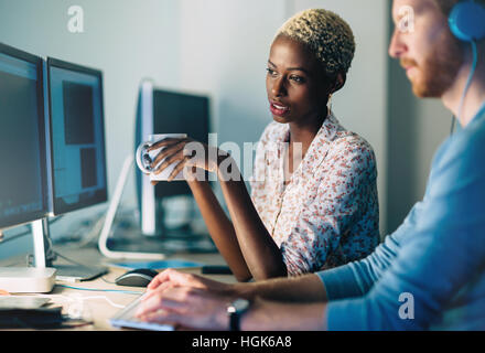 Programmers cooperating at  IT company developing apps Stock Photo