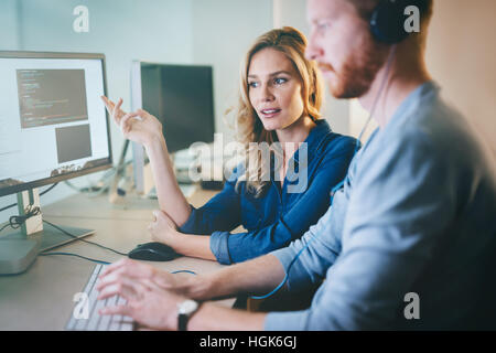 Programmers cooperating at  IT company developing apps Stock Photo
