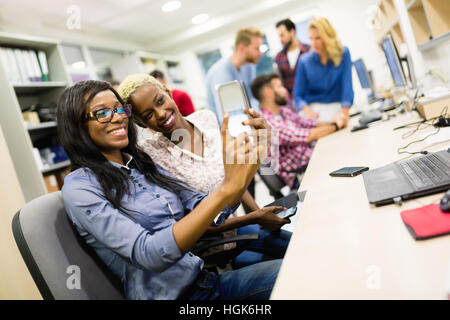 Happy colleagues taking selfies at  workplace office Stock Photo