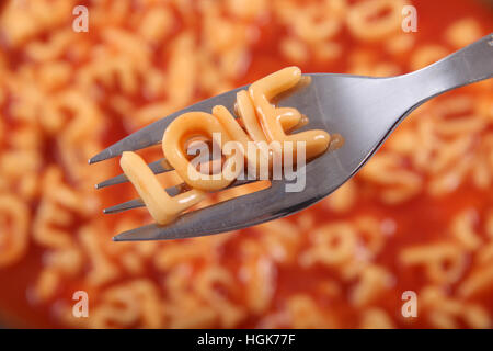 Spaghetti letter spelling the word Love with the letters held up on a fork.