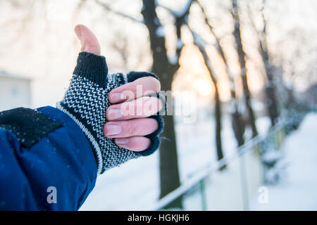 Male hand showing thumbs up in winter gloves outdoors Stock Photo