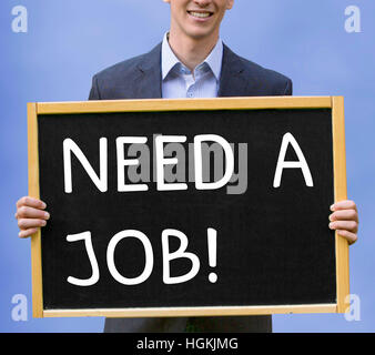 young businessman holding chalkboard with the words Need A Job Stock Photo