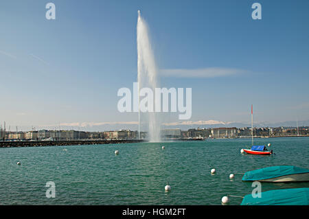 Famous Jet d'Eau fountain in Geneva Switzerland with snow capped Jura mountains in the background. Stock Photo