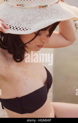 Young woman wearing a black bikini in a natural pool at summer