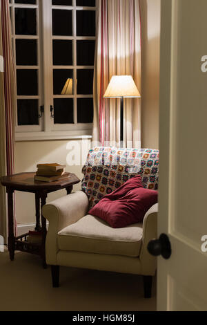 cosy reading chair inside home at night Stock Photo