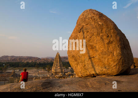 Man looking at the Virupaksha temple of Hampi, from Hemakuta Hill, Hampi.The Virupaksha Temple viewed from Hermakuta Hill. Stock Photo